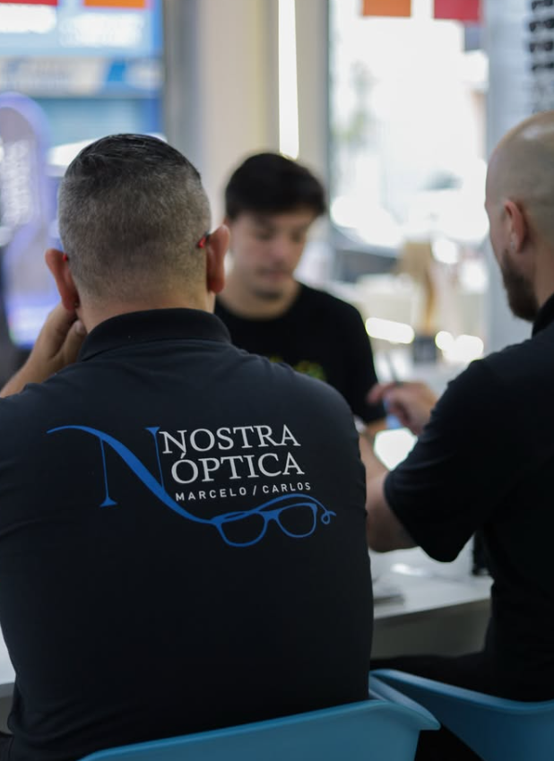 Equipe da Nostra Óptica atendendo um cliente no balcão da loja