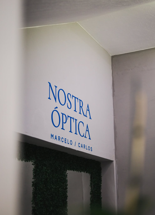 Logotipo azul da Nostra Óptica aplicado na parede interna da loja