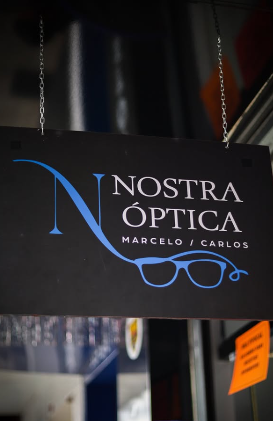 Placa suspensa da Nostra Óptica Marcelo / Carlos na entrada da loja